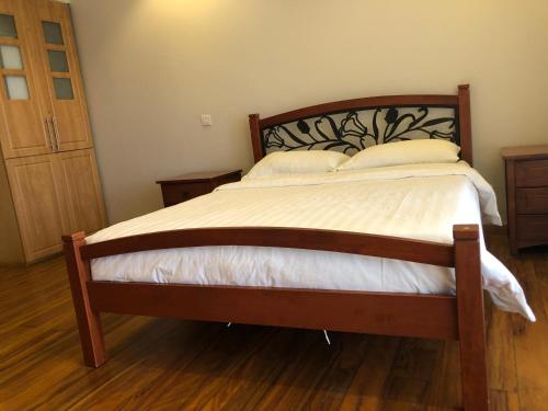 a bedroom with a large bed with a wooden headboard at Enkombe Place in Kampala