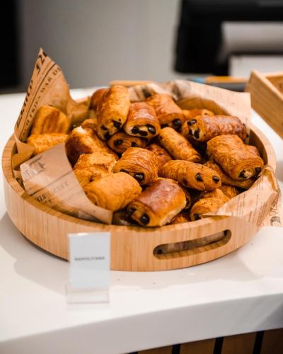 a wooden bowl of pastries on a table at YOTEL Porto in Porto