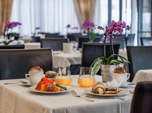 a table with two plates of food and orange juice at Hotel Ligure in Alassio