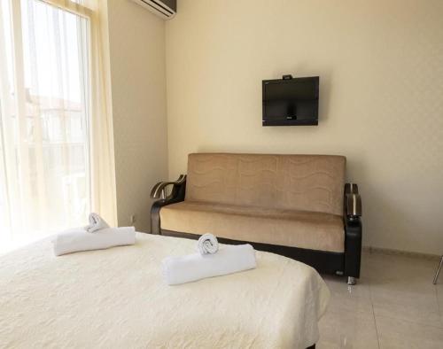 Un dormitorio con dos camas y un televisor en la pared. en Apartment Orbi Lux, en Batumi