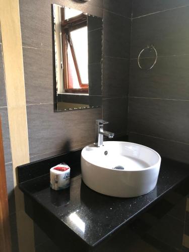 a bathroom with a white sink and a mirror at Enkombe Place in Kampala
