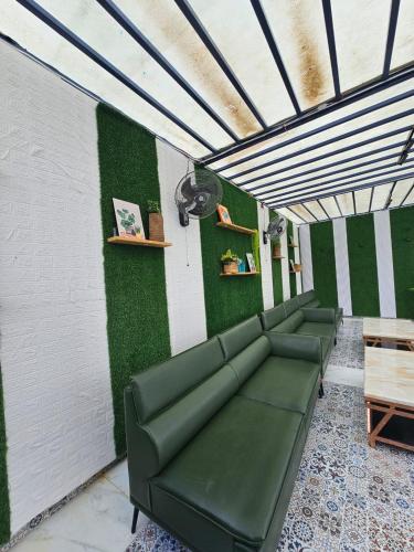 a waiting room with green walls and a couch at Rooftop With Pool Party 3BHK Luxury Space in Faridabad