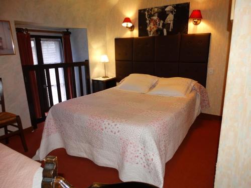 a bedroom with a large bed and a window at Chambres d'Hôtes de la Ferme Auberge de Mésauboin in Billé