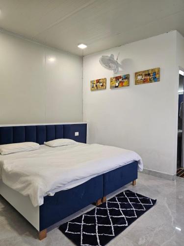 a bedroom with a blue and white bed and a rug at Rooftop With Pool Party 3BHK Luxury Space in Faridabad