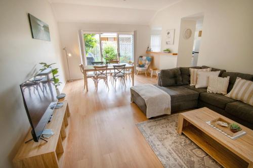 a living room with a couch and a table at Coastal Garden Villa in Albany
