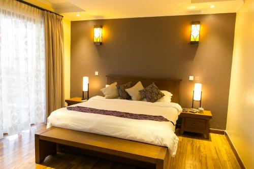 a bedroom with a large bed and a window at Enkombe Place in Kampala