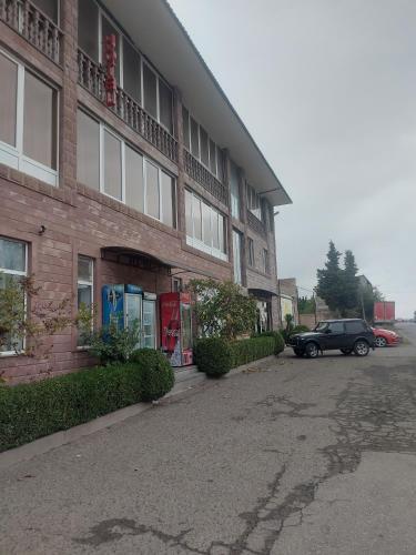a car parked in front of a brick building at Kantegh Hotel in Ijevan