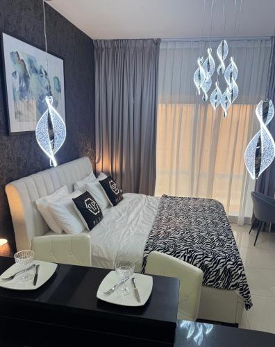 a bedroom with a bed and a table with plates on it at Big studio, Dubai SportCity, parking included in Dubai