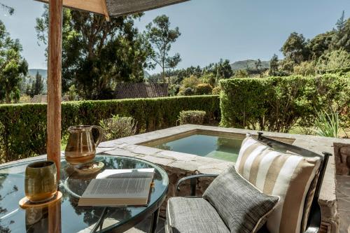 a table with a book and a laptop on a patio at Las Casitas, A Belmond Hotel, Colca Canyon in Yanque