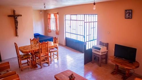 a living room with a dining room table and a television at Casa YilZil in Alpuyeca
