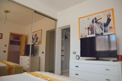 a living room with a tv on a dresser with a mirror at Boutique Citadel in Eforie Nord