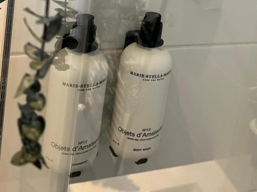 Dos botellas de champú blanco sobre el lavabo del baño. en Hotel Sutor, en Breda