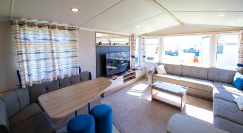 a living room with a couch and a tv at Willow Way 169 - Camber Sands in Camber