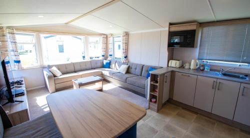 a living room with a couch and a table at Willow Way 169 - Camber Sands in Camber