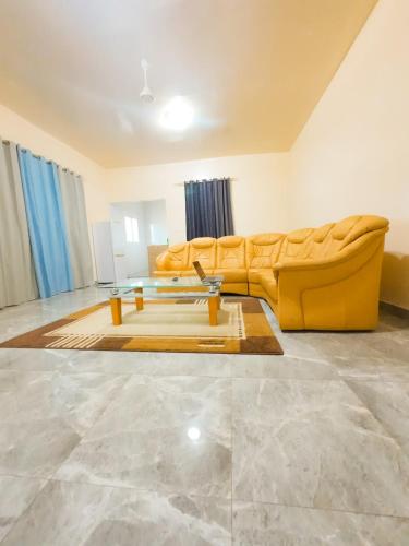 a living room with a yellow couch and a table at Apartments in Sukuta high way in Serekunda