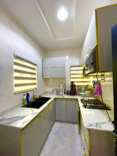 a kitchen with white counters and a sink and a stove at Your home away from home in Lagos
