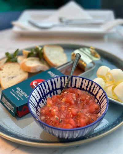 a bowl of salsa on a plate with bread and cheese at Hotel Ligure in Alassio