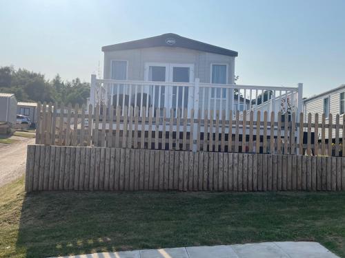 a wooden fence in front of a house at Ladram Bay Holiday Park D82 in Otterton