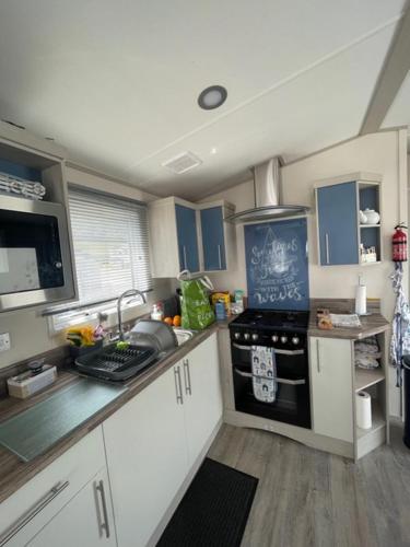 a kitchen with a sink and a stove top oven at Ladram Bay Holiday Park D82 in Otterton