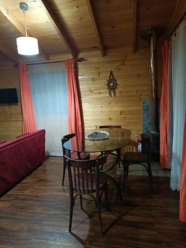 a room with a table and chairs and a couch at Casa Lelikelen dos dormitorios in Caburgua