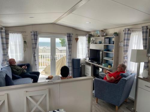 a group of people sitting in chairs in a living room at Ladram Bay Holiday Park D82 in Otterton