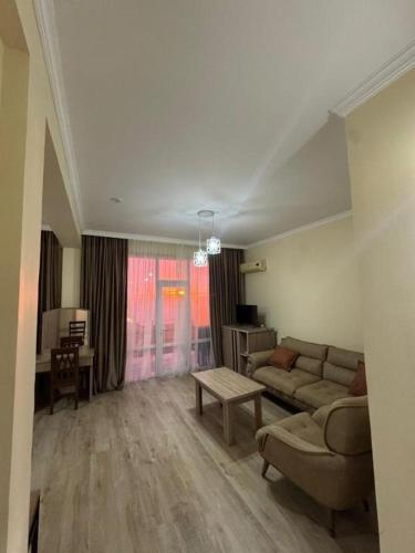 a living room with a couch and a table at Hotel Lazuri in Kvariati