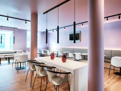 a dining room with tables and chairs and a tv at B&B Hotel Eisenach in Eisenach