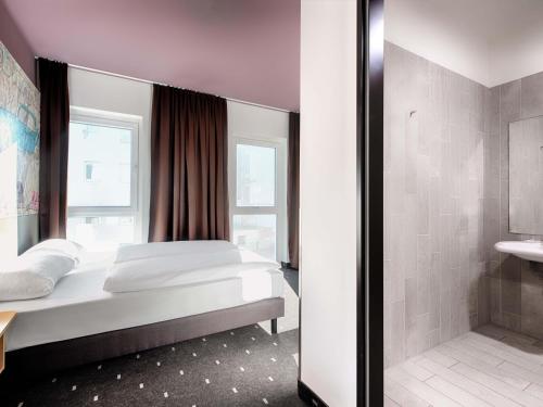 a bedroom with a large bed and a shower at B&B Hotel Eisenach in Eisenach
