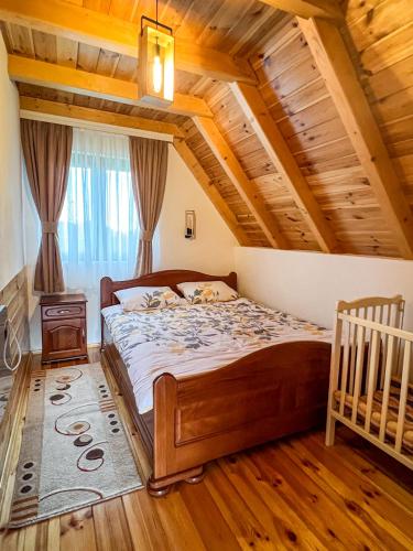 a bedroom with a bed and a wooden ceiling at Villas Hidden Paradise in Žabljak