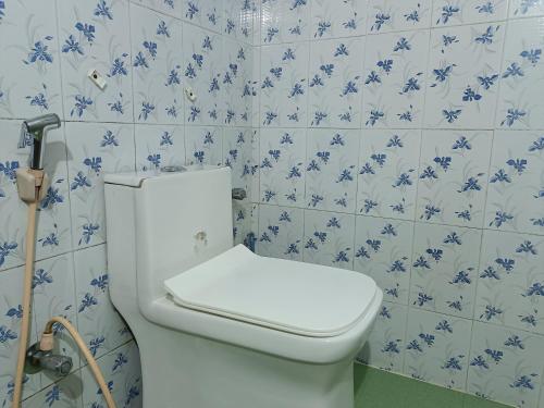 a bathroom with a toilet with blue and white tiles at Coorg villa homestay in Madikeri