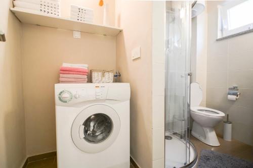 a bathroom with a washing machine and a toilet at Holiday Home Sunset in Zadar