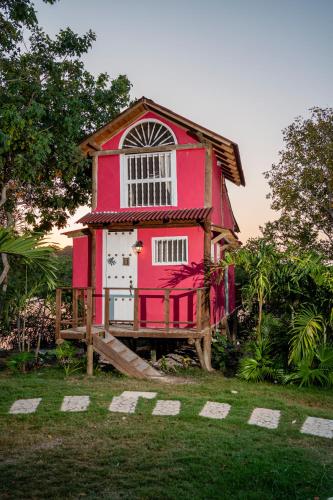 a red house on a wooden deck with a porch at Tiny Village Cartagena Boutique Resort in Tierra Bomba