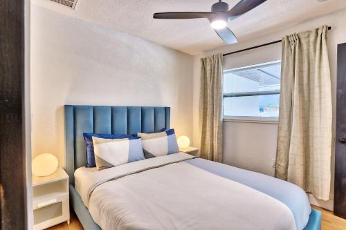 a bedroom with a bed with a blue headboard and a window at Parrots Cove in St Pete Beach