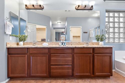 une salle de bain avec deux lavabos et un grand miroir dans l'établissement Chill & Thrill | Pool, Hot Tub • Family Game Villa, à Casa Grande