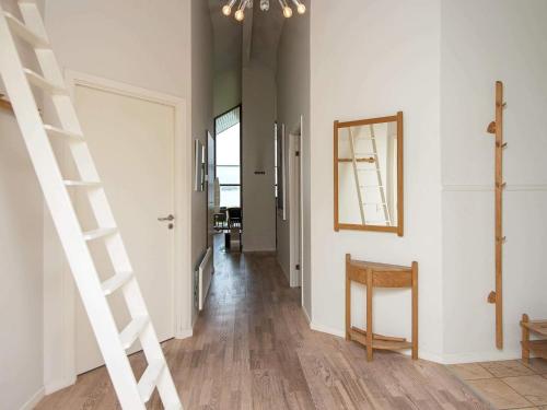 a hallway with a staircase and a mirror on the wall at 6 person holiday home in Egernsund-By Traum in Egernsund