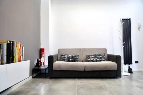 a living room with a couch and a book shelf at Davide Host LH89, 30min Duomo in Sesto San Giovanni