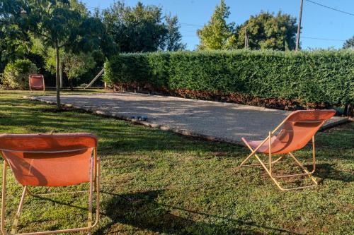 two orange chairs sitting in the grass in a yard at Le Logis Chez Bompain in Brizambourg