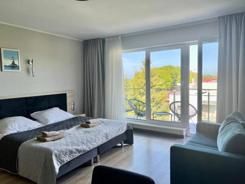 ein Schlafzimmer mit Bett und Blick auf einen Balkon in der Unterkunft Apartament Morza Szum in Sianożęty