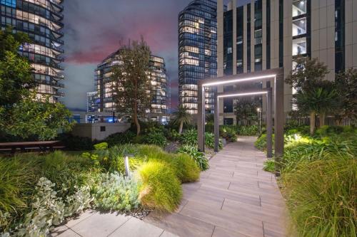 a garden in a city at night with tall buildings at Docklands Harbour & City Views Pool, Free Onsite Parking , Yoga & Gym in Melbourne