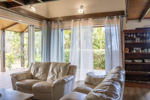 a living room with a couch and some windows at Villa Ti Gargoulette in Saint-Joseph