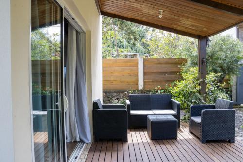 a patio with chairs and tables on a deck at Villa Ti Gargoulette in Saint-Joseph