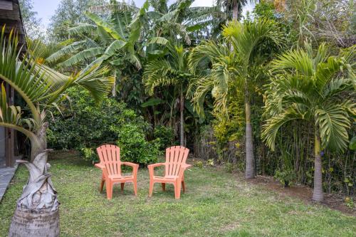 two chairs sitting in the grass near some trees at Villa Ti Gargoulette in Saint-Joseph