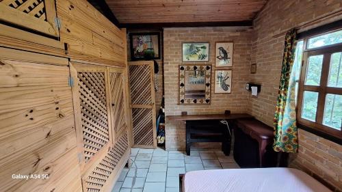 a room with a fireplace in a wooden cabin at Casa rustica Ilhabela a 200 m da praia do Julião in Ilhabela
