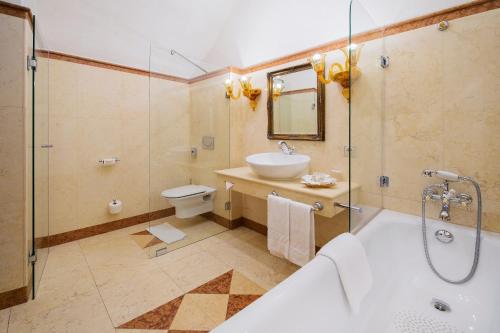 a bathroom with a tub and a sink and a toilet at Arcadia Boutique Hotel in Bratislava