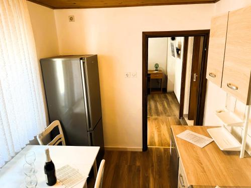 a kitchen with a stainless steel refrigerator and a table at Apartment Tina in Karojba