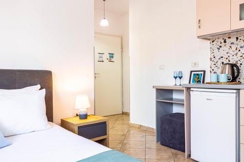 a bedroom with a bed and a kitchen with a table at Downtown Studio - Cozy, Kitchen & Easy Access in Himare