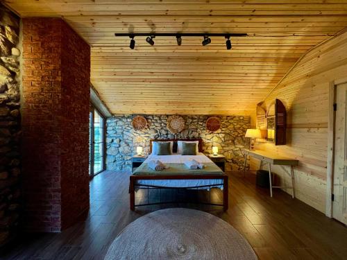 a bedroom with a bed in a wooden room at Villa Stone House in Kutaisi Heliport