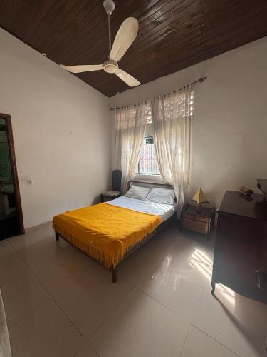 a bedroom with a yellow bed and a window at Casa sol en el jardin - piscina y relajacion total in Carmen de Apicalá