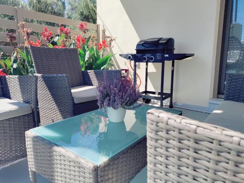 a table with a grill on a patio with flowers at LIVAS Residence in Tympáki