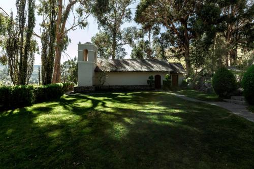a small white chapel in a yard with trees at Las Casitas, A Belmond Hotel, Colca Canyon in Yanque